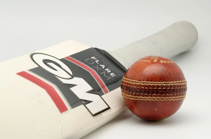A Gunn and Moore cricket bat and a red cricket ball
