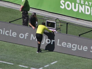 Referee Baldomero Toledo at a pitchside video-review monitor