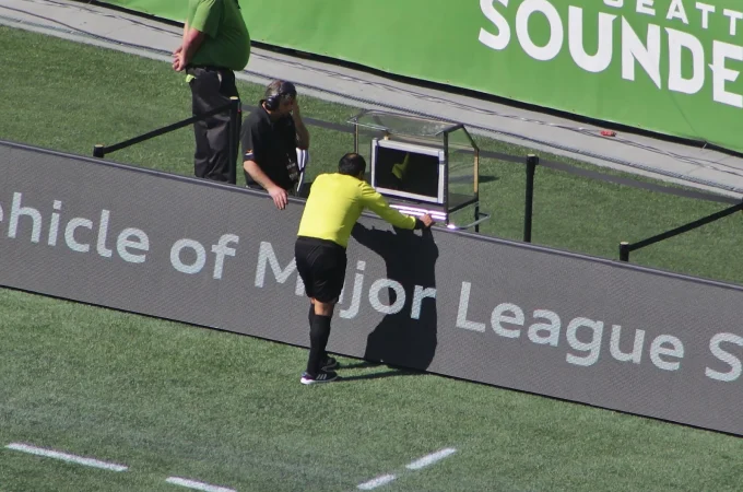 Referee Baldomero Toledo at a pitchside video-review monitor